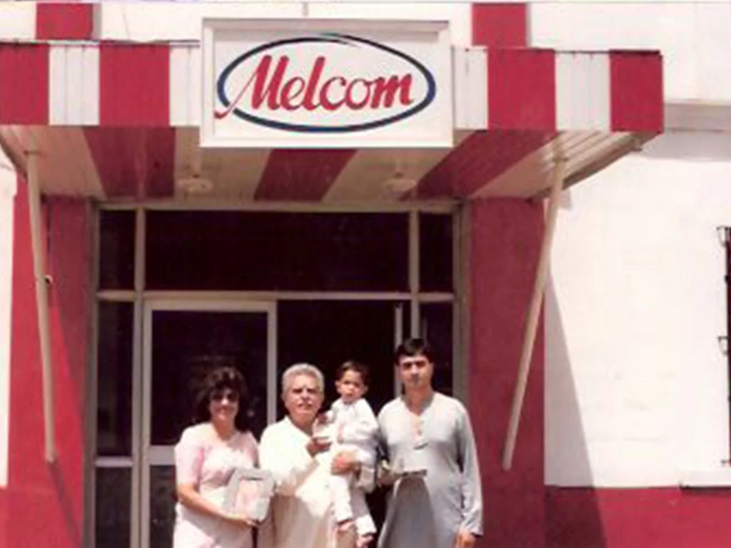 Undated Melcom entrance photograph reproduced in the company’s founder memoir. Branch, occasion and people are not independently confirmed.